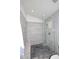 Close up of a tile shower with gray stone flooring, a built in bench, and glass doors at 3122 E Kristal Way, Phoenix, AZ 85050