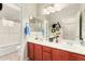 Well-lit bathroom with dual sinks, cherry cabinets, and shower/tub combo, offering both style and functionality at 3644 E Del Rio St, Gilbert, AZ 85295