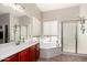 Bright bathroom featuring double sinks, a large tub, and a separate glass-enclosed shower at 3644 E Del Rio St, Gilbert, AZ 85295