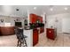 Open kitchen with breakfast bar, island, tile floors and cherry wood cabinetry that overlooks living area at 3644 E Del Rio St, Gilbert, AZ 85295