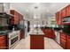Spacious kitchen features stainless steel appliances, granite countertops, island, and cherry wood cabinets at 3644 E Del Rio St, Gilbert, AZ 85295