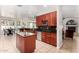 Modern kitchen with stainless steel appliances, island, granite counters, and ample cherry wood cabinets at 3644 E Del Rio St, Gilbert, AZ 85295