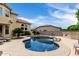 Beautiful kidney-shaped pool with a waterfall feature and a view of the two-story home at 3644 E Del Rio St, Gilbert, AZ 85295