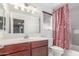 Bathroom with a large mirror, vanity sink and bathtub with shower and patterned shower curtain at 4135 E Waterman Ct, Gilbert, AZ 85297