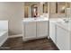Bright bathroom featuring double sinks, tile floors and a large mirror at 41413 W James Ln, Maricopa, AZ 85138