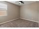 Simple bedroom with neutral carpet, paint and a ceiling fan at 41413 W James Ln, Maricopa, AZ 85138