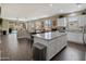 Open kitchen featuring white cabinetry, granite countertops, stainless steel appliances and backyard pool view at 41413 W James Ln, Maricopa, AZ 85138