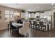 Open kitchen featuring white cabinetry, granite countertops, stainless steel appliances and dining area at 41413 W James Ln, Maricopa, AZ 85138