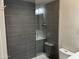 Modern shower with dark tile walls, glass doors, and a built-in seat in bathroom at 4750 N Central Ave # A10, Phoenix, AZ 85012