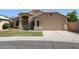 Well-manicured home featuring a beige exterior, arched entryway, and attached two-car garage at 5010 W Ivanhoe St, Chandler, AZ 85226