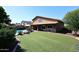 Lush artificial turf backyard with a sparkling pool, and covered patio ideal for relaxation and leisure at 5879 E Marconi Ave, Scottsdale, AZ 85254