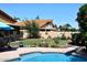Relaxing backyard oasis with pool, lush artificial turf, and beautifully landscaped flower beds at 5879 E Marconi Ave, Scottsdale, AZ 85254