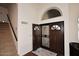 Elegant foyer with dark wood double doors, a decorative arched window, and beautiful hardwood floors with a neutral rug at 5879 E Marconi Ave, Scottsdale, AZ 85254
