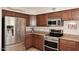 Bright kitchen featuring stainless steel appliances, granite countertops, and stylish wood cabinetry at 5879 E Marconi Ave, Scottsdale, AZ 85254