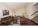 Cozy living room with hardwood floors, a staircase, vaulted ceilings, and comfortable brown sofas at 5879 E Marconi Ave, Scottsdale, AZ 85254