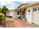 Inviting front entrance with brick porch, seating, an American flag, and vibrant flowers at 6311 E Calle Rosa --, Scottsdale, AZ 85251