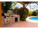 A built-in brick outdoor kitchen area features a stainless steel grill, perfect for entertaining near the pool at 6311 E Calle Rosa --, Scottsdale, AZ 85251