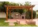 Backyard featuring an outdoor kitchen, brick accents, and pergola creating an ideal space for entertaining at 6311 E Calle Rosa --, Scottsdale, AZ 85251
