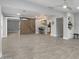 Spacious living area featuring tile floors, a barn door, and an adjacent kitchen with a breakfast bar at 717 E Palmaire Ave, Phoenix, AZ 85020