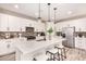 Bright kitchen with white cabinets, stainless steel appliances, a center island, and modern pendant lighting at 734 W Winchester Dr, Chandler, AZ 85286