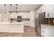 Modern kitchen boasting white cabinets, tile backsplash, stainless steel appliances, and a center island with bar seating at 734 W Winchester Dr, Chandler, AZ 85286