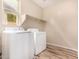 Laundry room featuring appliances, shelving, wood floors, and a window providing natural light at 734 W Winchester Dr, Chandler, AZ 85286