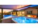 A luxurious backyard featuring a pool, hot tub, fire pit, outdoor seating, and covered patio at 8149 E Jaeger St, Mesa, AZ 85207