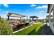Lush backyard boasting a fire pit, outdoor kitchen, covered patio, and sparkling pool at 8149 E Jaeger St, Mesa, AZ 85207