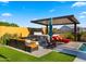 Inviting backyard featuring a fire pit, lounge chairs, hot tub, and covered patio at 8149 E Jaeger St, Mesa, AZ 85207