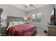 Bedroom with wood-look floors, neutral walls, a ceiling fan, and a large bed at 8149 E Jaeger St, Mesa, AZ 85207