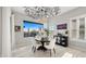 Bright dining room featuring modern chandelier, round table, and large picture window at 8149 E Jaeger St, Mesa, AZ 85207