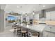 Kitchen island with sink and seating, stainless steel appliances, and white cabinetry at 8149 E Jaeger St, Mesa, AZ 85207
