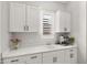 Bright kitchenette featuring white cabinetry and countertop with stainless coffee machine at 8149 E Jaeger St, Mesa, AZ 85207