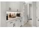 Close up view of a bright kitchenette with white cabinets, counter, and a beverage station at 8149 E Jaeger St, Mesa, AZ 85207
