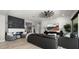Open-concept living room with a stone fireplace, sleek furniture, and a large TV for entertainment at 8149 E Jaeger St, Mesa, AZ 85207
