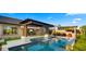 Picturesque backyard pool area with a pergola, dining space, and lush landscaping, offering a private oasis for relaxation at 8149 E Jaeger St, Mesa, AZ 85207