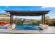 Beautiful pool with a pergola, water features, lounge chairs, and manicured greenery, creating a serene backyard oasis at 8149 E Jaeger St, Mesa, AZ 85207