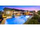 Backyard oasis featuring a swimming pool with waterfall, hot tub, outdoor kitchen, and lounge area at 8149 E Jaeger St, Mesa, AZ 85207