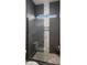 Stylish shower featuring decorative tile, a built-in bench, and glass enclosure at 8149 E Jaeger St, Mesa, AZ 85207