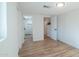Bright bedroom featuring hardwood floors and white trim with bathroom visible in attached ensuite at 832 S Drew St, Mesa, AZ 85210