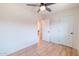 Light-filled bedroom featuring wood-look floors and ceiling fan, living room visible through doorway at 832 S Drew St, Mesa, AZ 85210