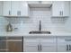 Updated kitchen features white cabinets, sleek hardware, quartz countertops and stainless steel appliances at 832 S Drew St, Mesa, AZ 85210