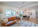 Cozy living room with a leather sofa, patterned rug, dining area, and bright natural light at 832 S Drew St, Mesa, AZ 85210