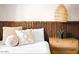 Bright bedroom featuring a wood slat headboard, woven nightstand, and a decorative hanging light fixture at 8734 E Amelia Ave, Scottsdale, AZ 85251