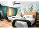 Bright bedroom with two beds, a tropical accent wall, and gold curtains at 8734 E Amelia Ave, Scottsdale, AZ 85251