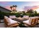 Beautiful backyard area with an outdoor fire pit, lounge seating, grill and lush landscaping at 8734 E Amelia Ave, Scottsdale, AZ 85251