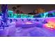Stylish outdoor lounge area with a cozy fire pit, comfortable seating, and vibrant LED lighting for evening relaxation at 8734 E Amelia Ave, Scottsdale, AZ 85251