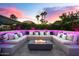 Inviting outdoor lounge area with cushioned seating, modern fire pit, and ambient lighting perfect for entertaining at 8734 E Amelia Ave, Scottsdale, AZ 85251