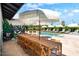 Spacious outdoor dining area and poolside lounge, perfect for enjoying meals with a view and entertaining guests at 8734 E Amelia Ave, Scottsdale, AZ 85251