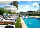 Backyard pool with lounge chairs, umbrellas, and water feature offers a relaxing outdoor space at 8734 E Amelia Ave, Scottsdale, AZ 85251